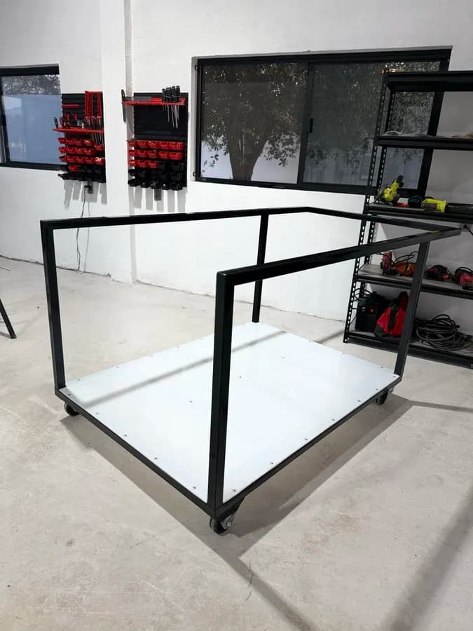 Carro industrial negro con ruedas en taller