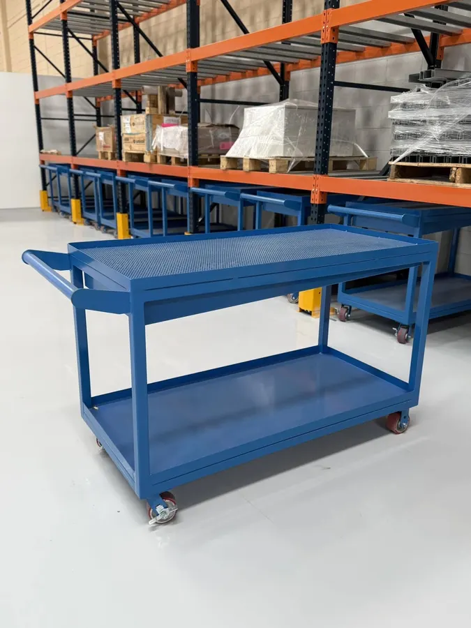 Mesa de trabajo industrial azul con superficie perforada